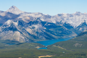 Overlooking Lake Minnewanka and surrounding Canadian Rocky Mountains in summer time. Banff National Park, Alberta, Canada.