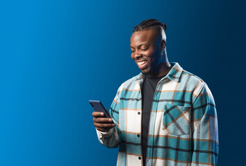 Handsome black man looking at mobile smiling.
