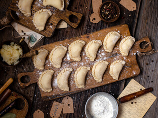 homemade raw dumplings on wooden board. traditional ukrainian food. overhead shot
