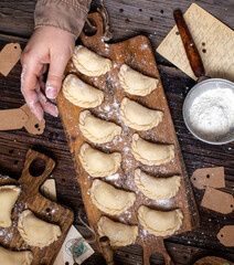 homemade raw dumplings on wooden board. traditional ukrainian food. overhead shot