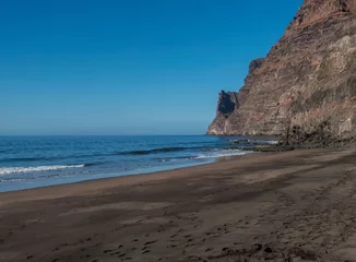 Foto op Canvas View of empty sand beach Playa de Guigui with rocky cliffs in west part of the Gran Canaria island, accessible only on foot from Barranco de Guigui Grande gorge or by boat. Canary Islands, Spain © Kristyna