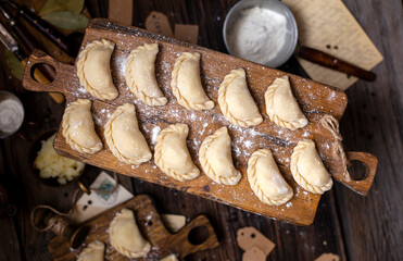 homemade raw dumplings on wooden board. traditional ukrainian food. overhead shot