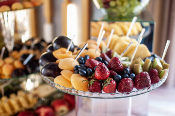 Fruit slicing at a wedding banquet. Watermelon, grapes, strawberry, orange, plum, pear, dinha, peach, kiwi, pineapple, persimmon, apple