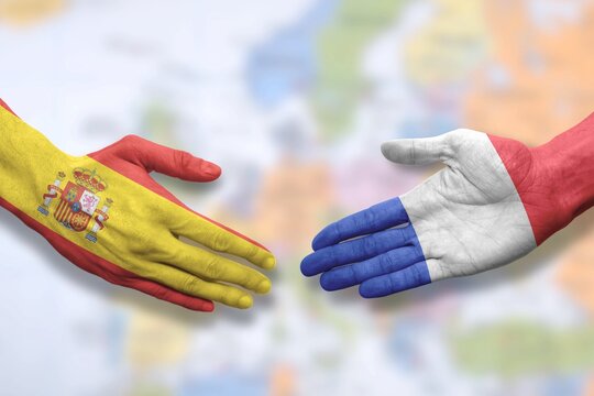 Spain and France - Flag handshake symbolizing partnership and cooperation