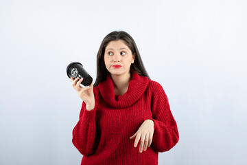 A young woman model in red sweater holding a cup of coffee