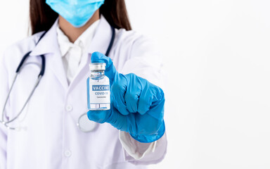 Fototapeta premium Blurred soft images of doctor woman Holding a vaccine bottle to treat the coronavirus of COVID-19 infection, On white background to health care and virus infection concept.