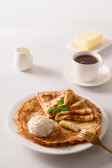 Russian thin pancakes or blini with whipped cream on white. Shrovetide. Traditional russian breakfast. Close up. Vertical format.