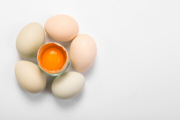 Opened egg with visible yolk in the middle around full eggs, easter card, happy easter