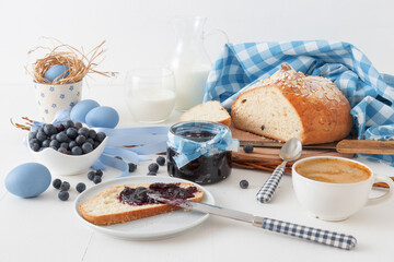 Easter breakfast or brunch table in blue style, embellished with Easter symbols,  traditional Czech Easter pastry Mazanec, Pomlazka and eggs.