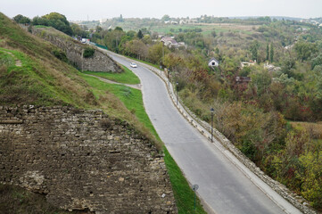 Fototapeta na wymiar View of the road that runs along the walls of the Kamyanets-Podolsk fortress and the Smotrych canyon
