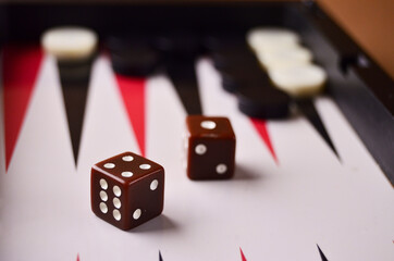 The dice are brown close-up on the backgammon board. Play a board game. High quality photo