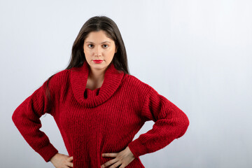 Portrait photo of a young woman model in red warm sweater standing
