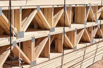 Prefab floor trusses stacked at a new home construction site, horizontal
