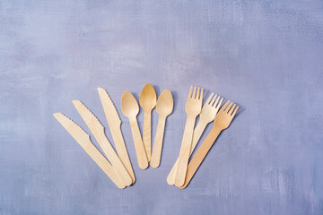 Eco Friendly Disposable tableware from natural materials. Wooden cutlery on natural gray stone background. Top view copy space