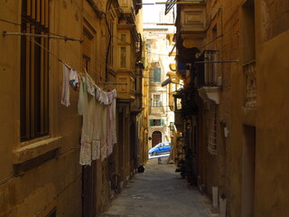 Wąska piesza uliczka w Valletcie na Malcie, wywieszone ubrania do suszenia,