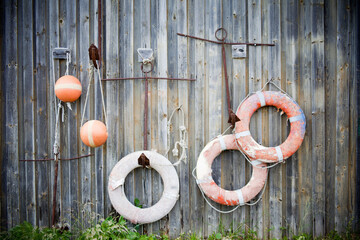 Lifebuoy on the wall of wooden fishing lodge with rope. Orange buoys