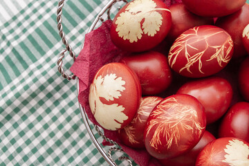 Painted Easter eggs in onion husks with abstract drawings are in a basket