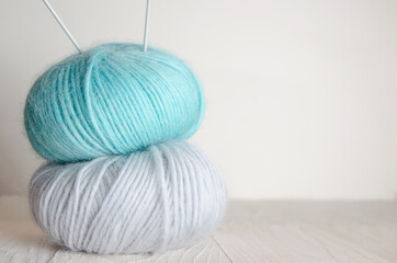Two skeins of wool yarn on a light wooden background. Knitting 