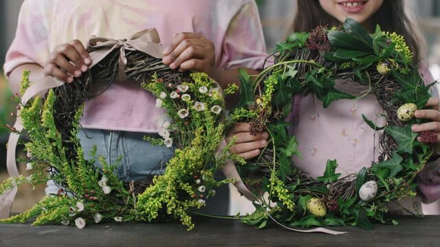 Close up mid-section shot of unrecognizable girls holding Easter flower wreaths