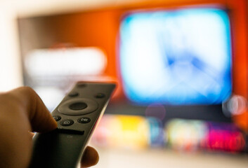 Una persona viendo películas por internet vía streaming en la sala con un control remoto de...