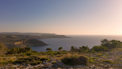 Pink sunset at the cliffs of Anchor Bay, Malta