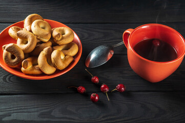 Homemade round bagels in an orange plate and rosehip tea. Idea for a delicious breakfast or dinner. Top view