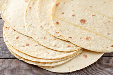 Grilled tortillas, flat breads on a wooden table, closeup