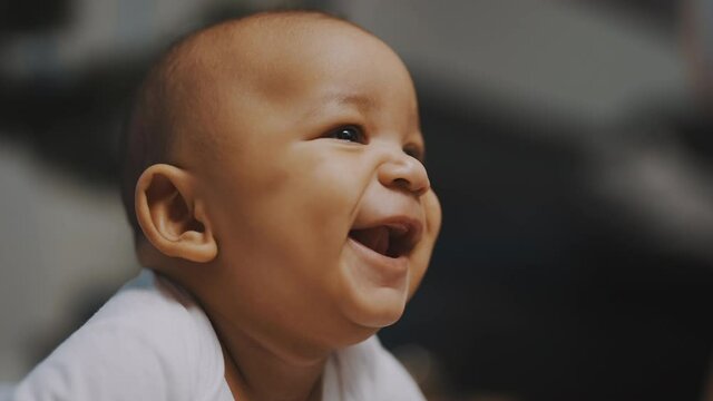 Portrait of adorable african american black baby. Baby laughing while having tummy time. High quality 4k footage