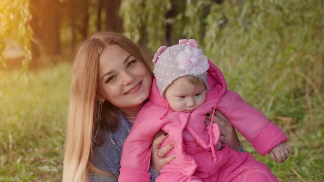 Happy young mother with her baby in the autumn evening.