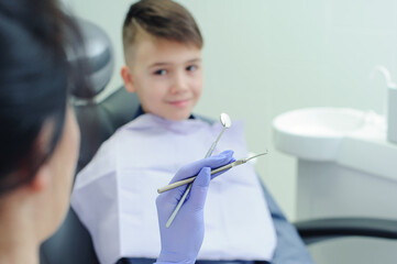 Dental tools in focus. A child boy with a dentist in a dental office.