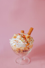 Delicate creamy dessert in a glass on a pink background.