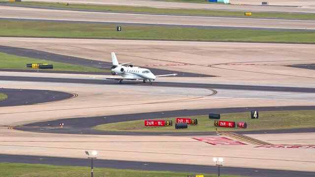 Generic Unmarked Private Business Jet Airplane Arriving at International Airport Taxiing after Landing on Runway on a Sunny Day
