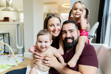 Portrait of happy family hugging in their home