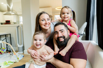 Portrait of happy family hugging in their home