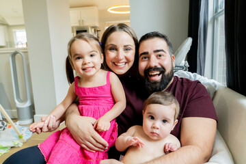 Portrait of happy family hugging in their home