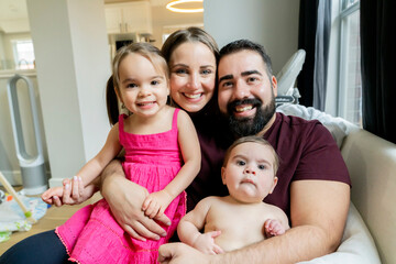 Portrait of happy family hugging in their home