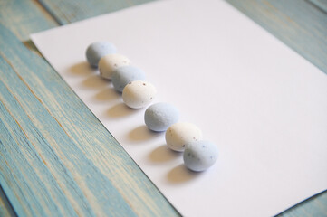 White sheet of paper on a wooden background. Easter list.