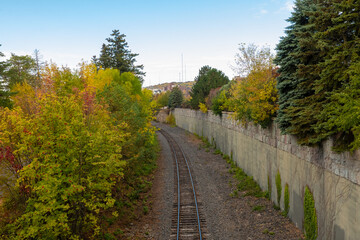 Curved Railroad Track in Duluth Minnesota with adjacent trees displaying early autumn colors.