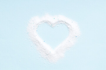 washing powder heap isolated on blue background. washing detergent cut out. heart symbol