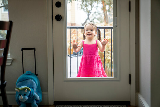 Girl With Face Pressed To Glass Door Looking Into House