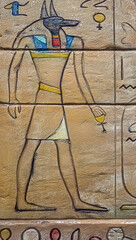 Egyptian god Anubis carved on wall with hieroglyphs