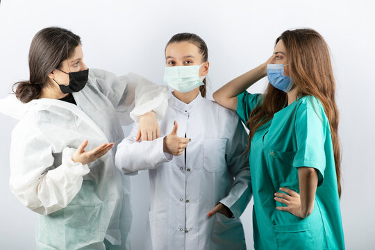 Three Young Female Doctors Standing And Posing On White Background