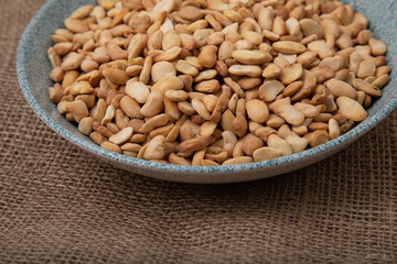 Salted crispy roasted broad beans in blue bowl on linen background