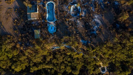 Aerial view of a pool, swimming pool and spa in deterioration due to being abandoned and burned,...