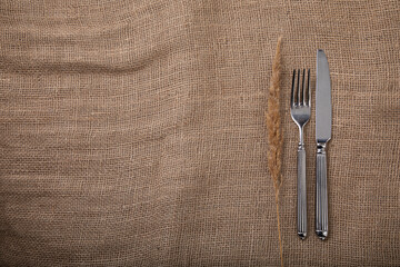 Silver cutlery, fork and knife on a linen textured fabric