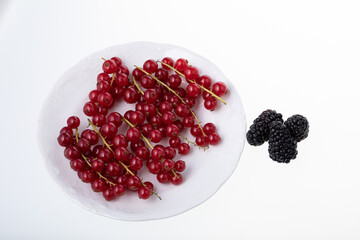 Fresh raw red currant berries on white plate