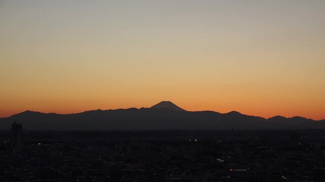 TOKYO, JAPAN : Aerial sunrise CITYSCAPE of TOKYO and MOUNT FUJI. View of rising sun, dawn sky and buildings. Japanese city life and nature concept. Long time lapse video, night to fresh early morning.
