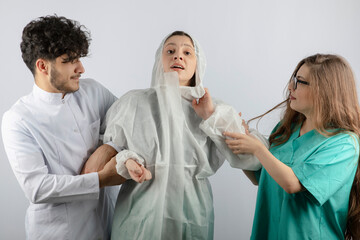 Obraz premium Three doctors standing and looking at each other on white background