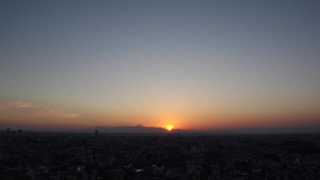 TOKYO, JAPAN : Aerial sunrise CITYSCAPE of TOKYO and MOUNT FUJI. View of rising sun, dawn sky and buildings. Japanese city life and nature concept. Long time lapse video, night to fresh early morning.