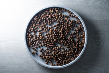 Brown roasted coffee beans falling on pile. Represent breakfast, energy, freshness or great aroma,Flying on dark background with copy space, close-up